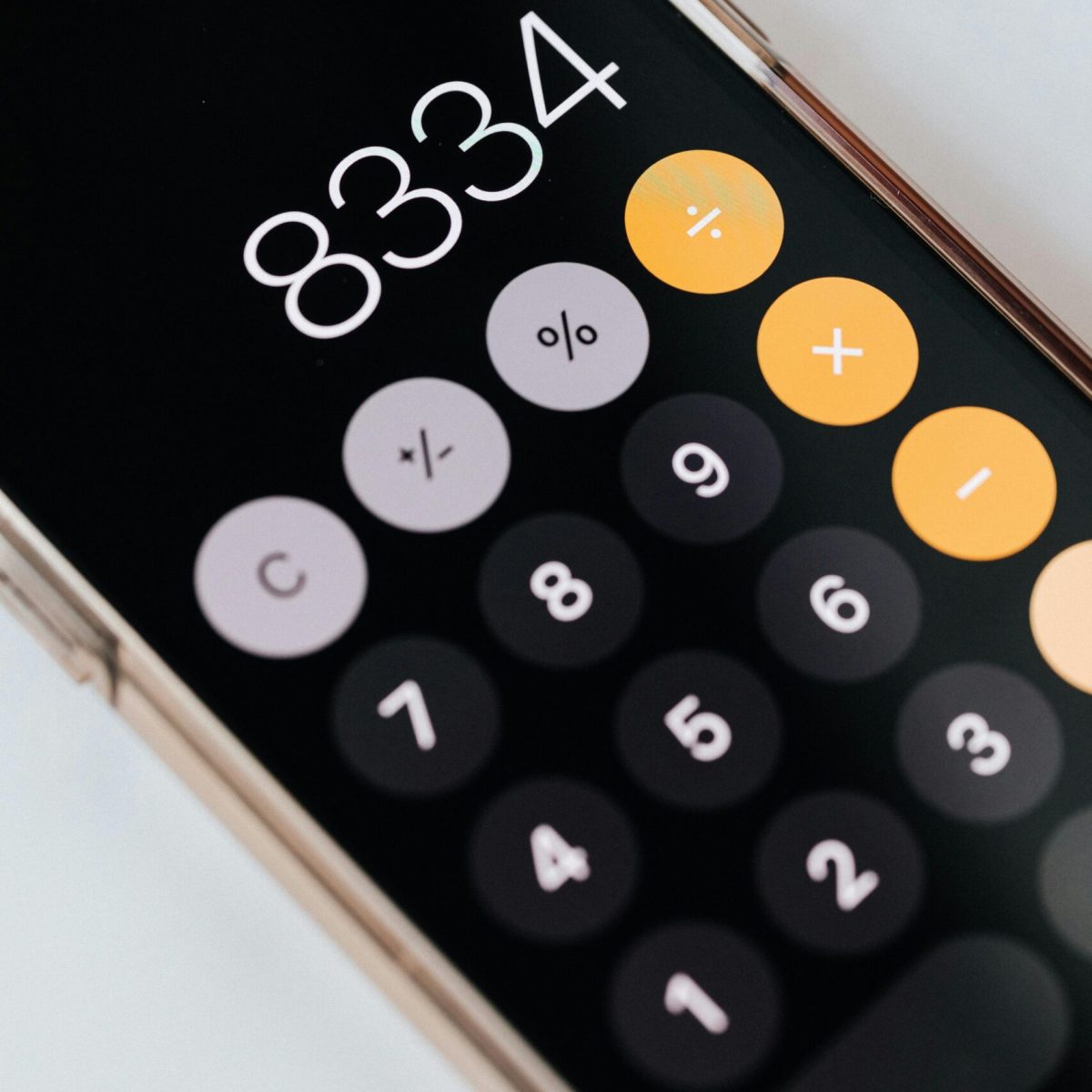 Close-up of a smartphone displaying a calculator app with numbers and symbols.